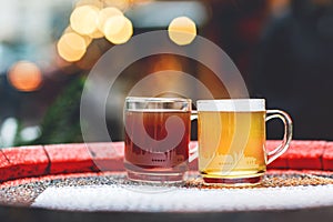 Two glasses mugs with red and white mulled wine on Christmas Market in Germany. Traditional alcoholic drinks on German