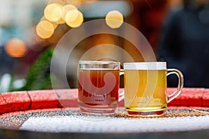 Two glasses mugs with red and white mulled wine on Christmas Market in Germany. Traditional alcoholic drinks on German