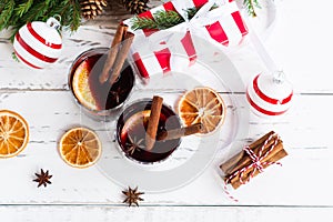 Two glasses of mulled hot wine decorated spicws and dry oranges. Festive greeting card for christmas holidays, top view