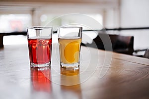 Two glasses with orange juice and pomegranate juice are on the table in a cafe. healthy drinks, smoothies, citro and lemonade clos photo