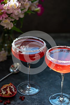 Two glasses with red pomegranate cocktail. Party, mixed colourful cocktail. Dark background