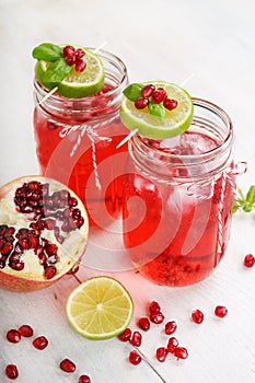 Two glasses with red pomgranate juice, lime and mint.