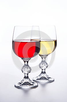 Two Glasses of red and white wine on light background