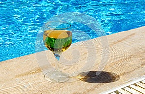 Two glasses of red and white wine are placed by the pool. The concept of a pleasant stay.