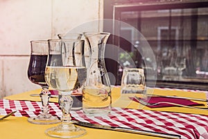 Two glasses of red and white wine served on a table in an traditional italian restaurant.