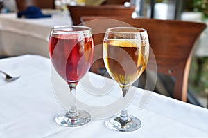 Two glasses with red and white wine stand on the table