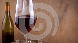 Two glasses of red wine. Alcoholic drink in a glass. A bottle of wine. Wooden background.
