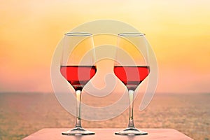 Two glasses of red wine on the background of the sea.