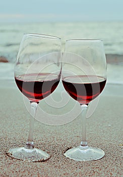Two glasses of red wine on the beach