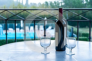 Two glasses of red wine and bottle on the balcony