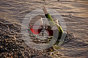 Two Glasses Red Wine and Bottle in Ocean