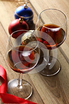 Two glasses of red wine and Christmas ornament on a wooden table with copy space for your text