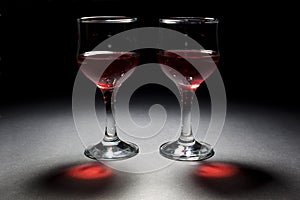 Two Glasses of Red Wine and Their Interesting Reflection On Black Background