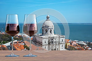 Two glasses of red wine on view of church of Santa Engracia National Pantheon in Lisbon, Portugal