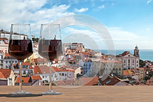 Two glasses of red wine on view of the Lisbon old town in Alfama district in Lisbon, Portugal
