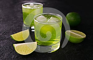Two glasses of refreshing lime drink on a black background. Close-up.