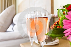 Two glasses of rose champagne in the upscale hotel room. Dating, romance, honeymoon, valentine, getaway, staycation