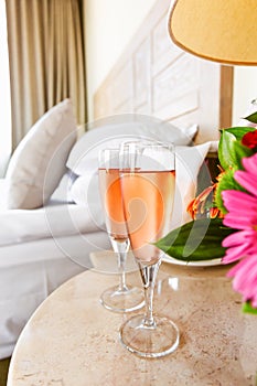 Two glasses of rose champagne in the upscale hotel room. Dating, romance, honeymoon, valentine, getaway, staycation