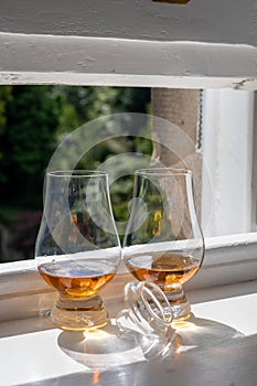 Two glasses of single malt scotch whisky served on old window sill in Scottisch house with view on old part of Edinburgh, Scotland