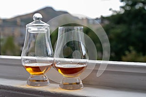 Two glasses of single malt scotch whisky served on old window sill in Scottisch house with view on old part of Edinburgh, Scotland