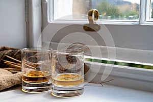 Two glasses of single malt scotch whisky served on old wooden window sill in Scottisch house in Edinburgh, Scotland, UK