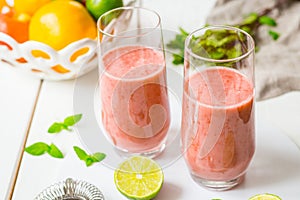 Two Glasses of Smoothie with Berries, Grapefruit, Lemon, Lime and Mint on White Wooden Background, Detox Time