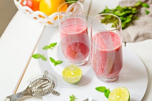 Two Glasses of Smoothie with Berries, Grapefruit, Lemon, Lime and Mint on White Wooden Background, Detox Time