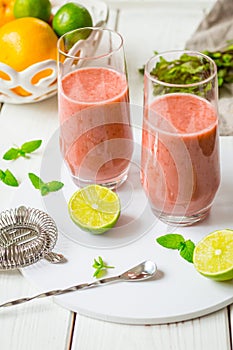 Two Glasses of Smoothie with Berries, Grapefruit, Lemon, Lime and Mint on White Wooden Background, Detox Time