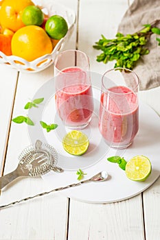 Two Glasses of Smoothie with Berries, Grapefruit, Lemon, Lime and Mint on White Wooden Background, Detox Time