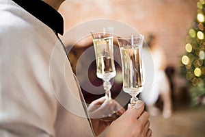 Two glasses with sparkling wine in male hands