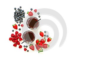 Two glasses of strawberries, raspberries, blueberries juice isolated on white.