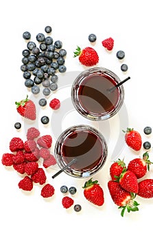 Two glasses of strawberries, raspberries, blueberries juice isolated on white.