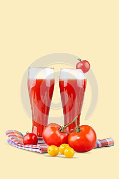 Two glasses with tomato juice and a small tomato on a bright background.