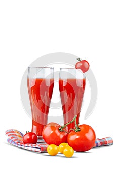 Two glasses with tomato juice and a small tomato on a bright background.