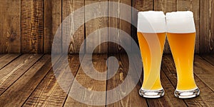 Two glasses of wheat beer making cheers on a wooden background