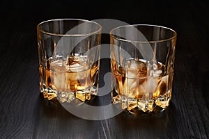 Two glasses of whiskey with ice cubes