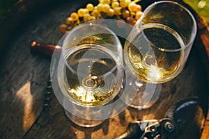 Two glasses of white wine on a barrel, top view