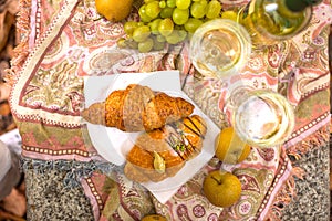 Two glasses of white wine and croissants on the table. Romance and autumn leaves. Top view. Copy space.