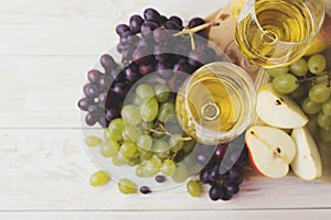 Two glasses of white wine, fresh grapes and pear