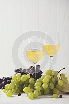 Two glasses of white wine, fresh grapes and pears