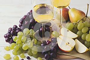 Two glasses of white wine, fresh grapes and pears