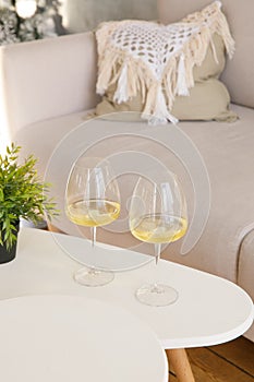 Two glasses of white wine are on the side table