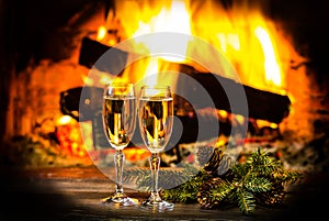 Two glasses of wine and Christmas New Year decoration, fireplace