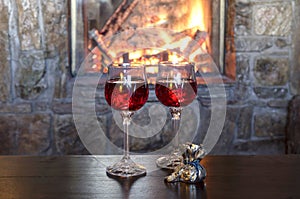 Two glasses of wine by the fireplace