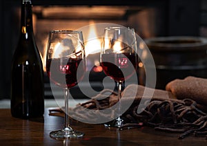 Two glasses of wine with fireplace in background