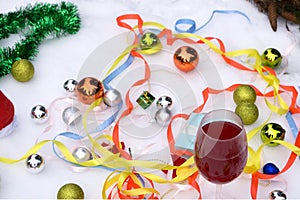 Two glasses of wine and gifts with a red satin ribbon, apples , pine cones, branches, gold ornaments garlands