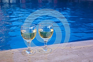 Two glasses with wine at the poolside