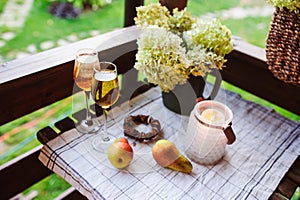 Two glasses of wine on summer table decorated with flowers.