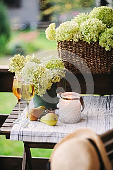 Two glasses of wine on summer table decorated with flowers.