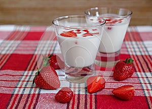 Two Glasses of Yogurt,Red Fresh Strawberries on the Check Tablecloth.Breakfast Organic Healthy Tasty Food.Cooking Vitamins
